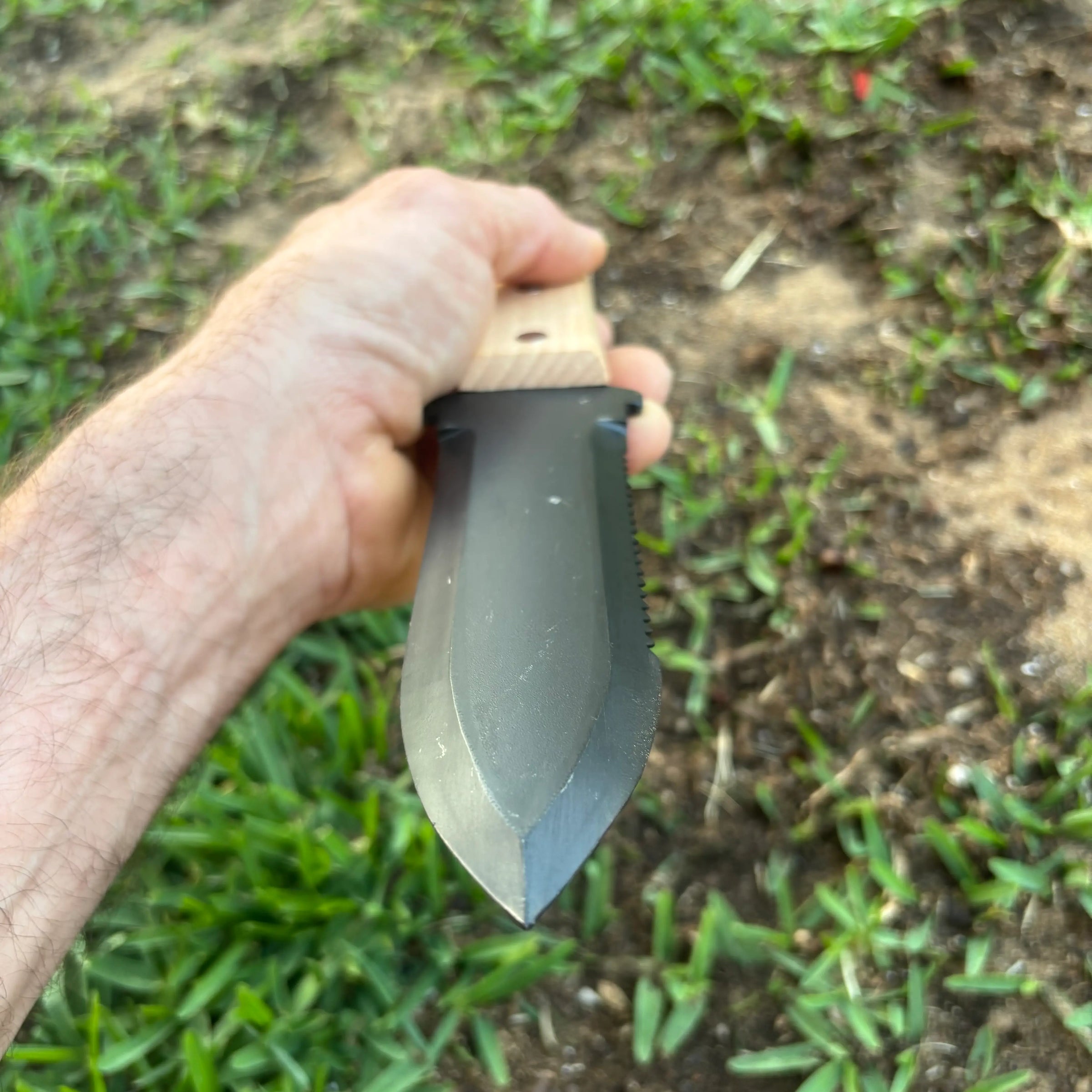 A gardener using a Hori Hori knife alongside Japanese digging tools in a Perth suburban garden