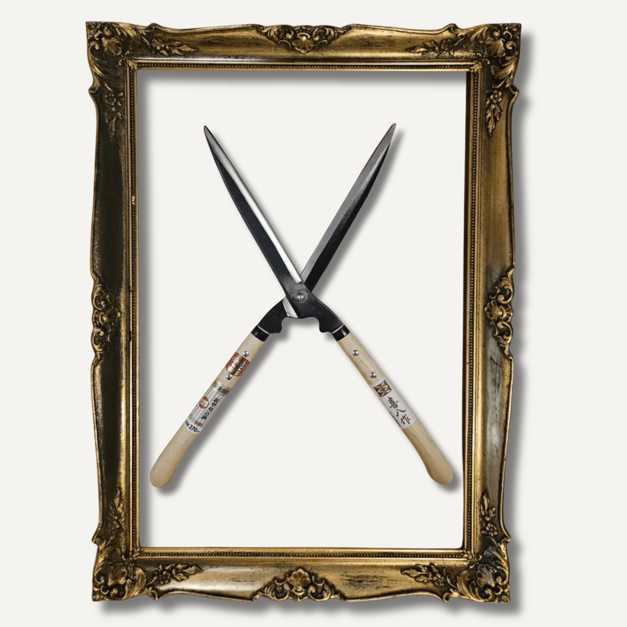 Crossed garden pruners inside an ornate gold frame on a white background