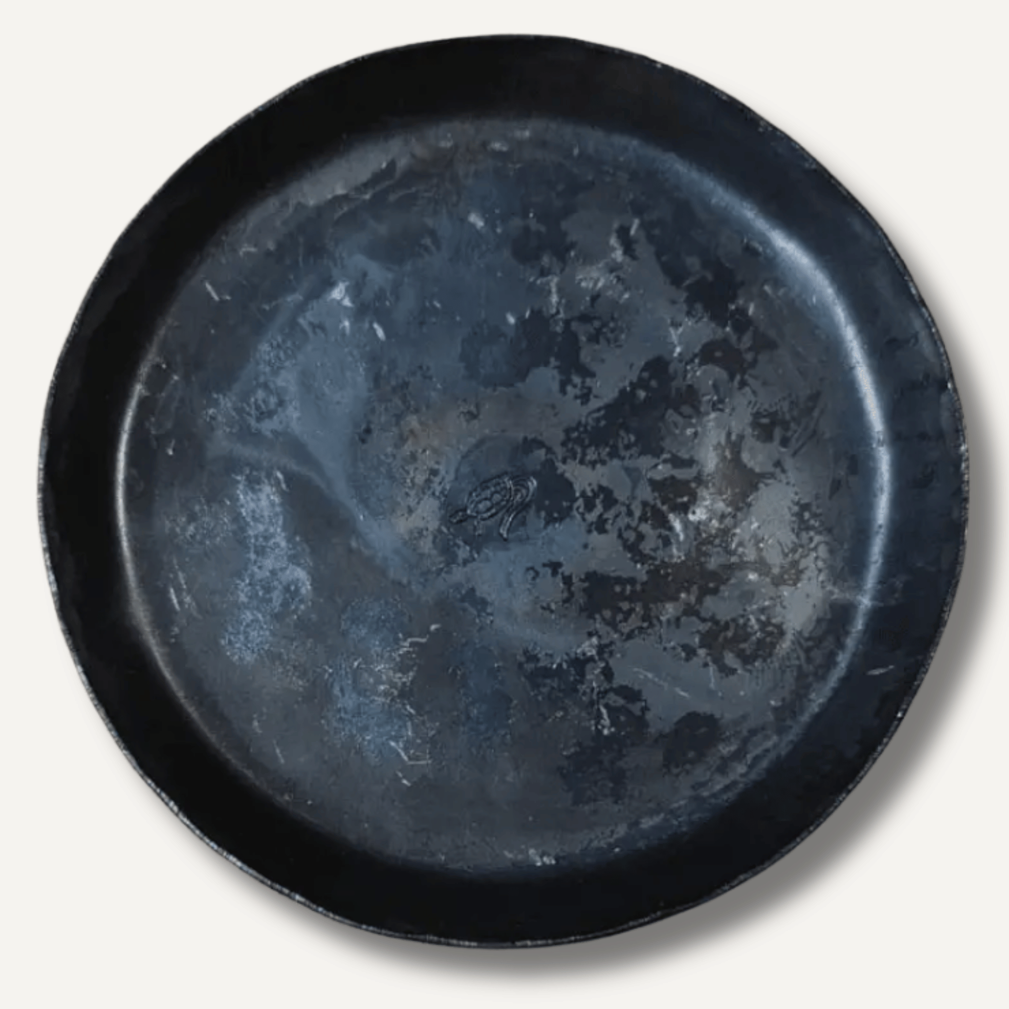 Black ceramic plate with a textured surface on a white background