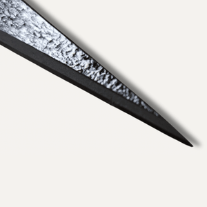 Close-up of a sword blade with a textured surface on a white background