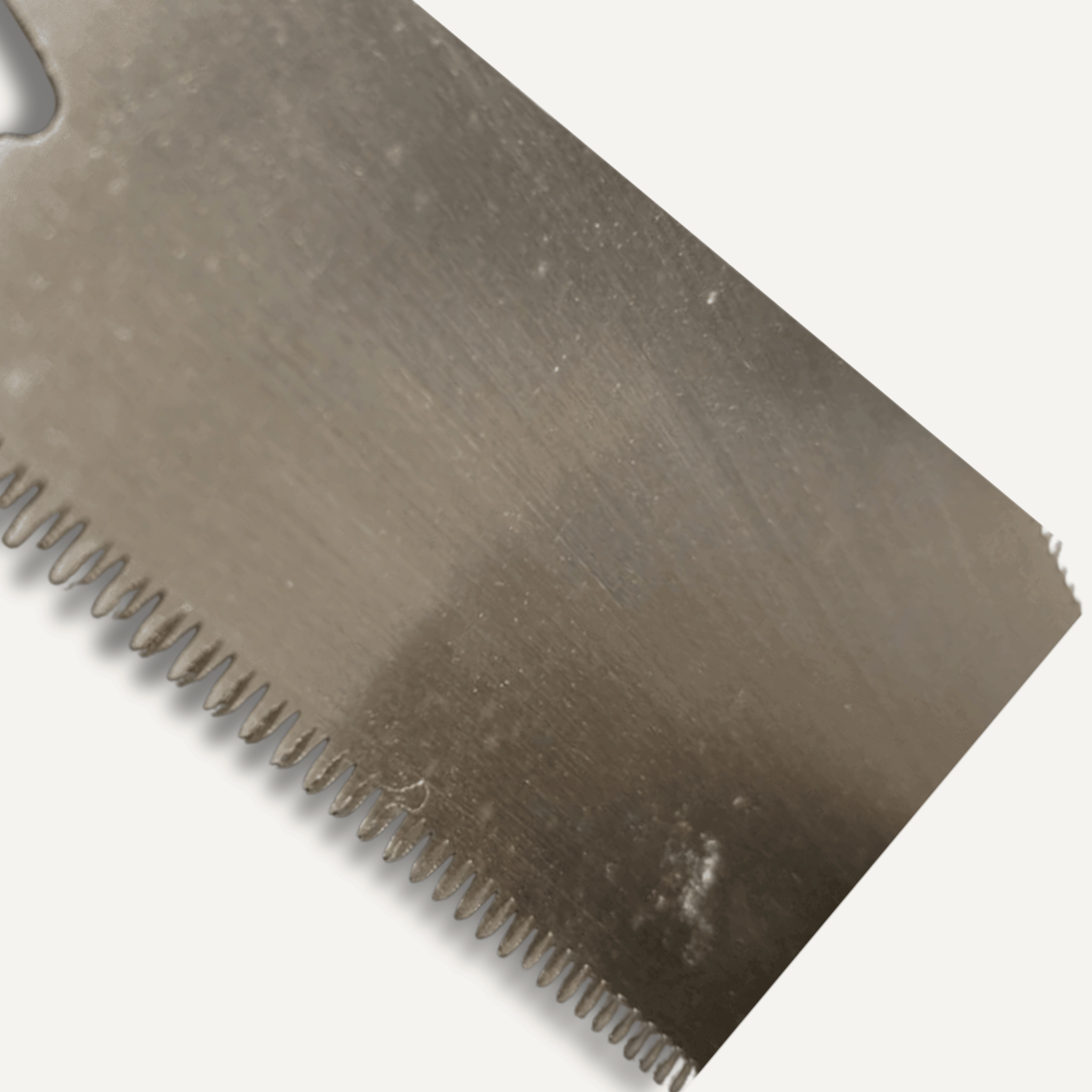 Close-up of a metal tool blade with teeth on a white background