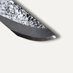 Close-up of a metallic blade with textured surface on a white background