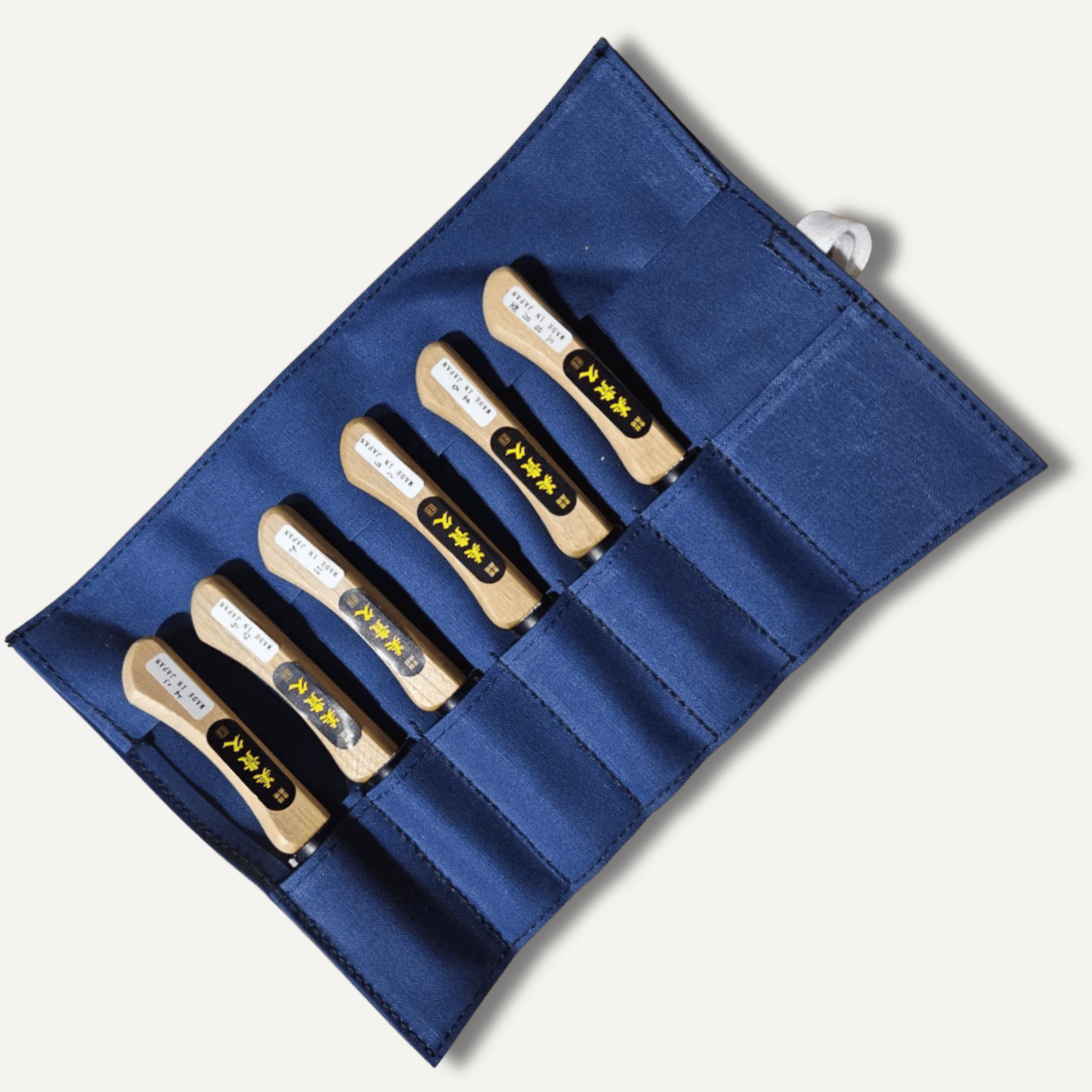 Set of 6 wooden tools with metal ends in a blue case on a white background