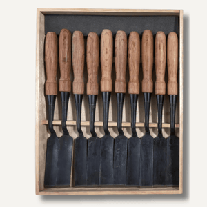 Set of chisels with wooden handles in a wooden box on a white background