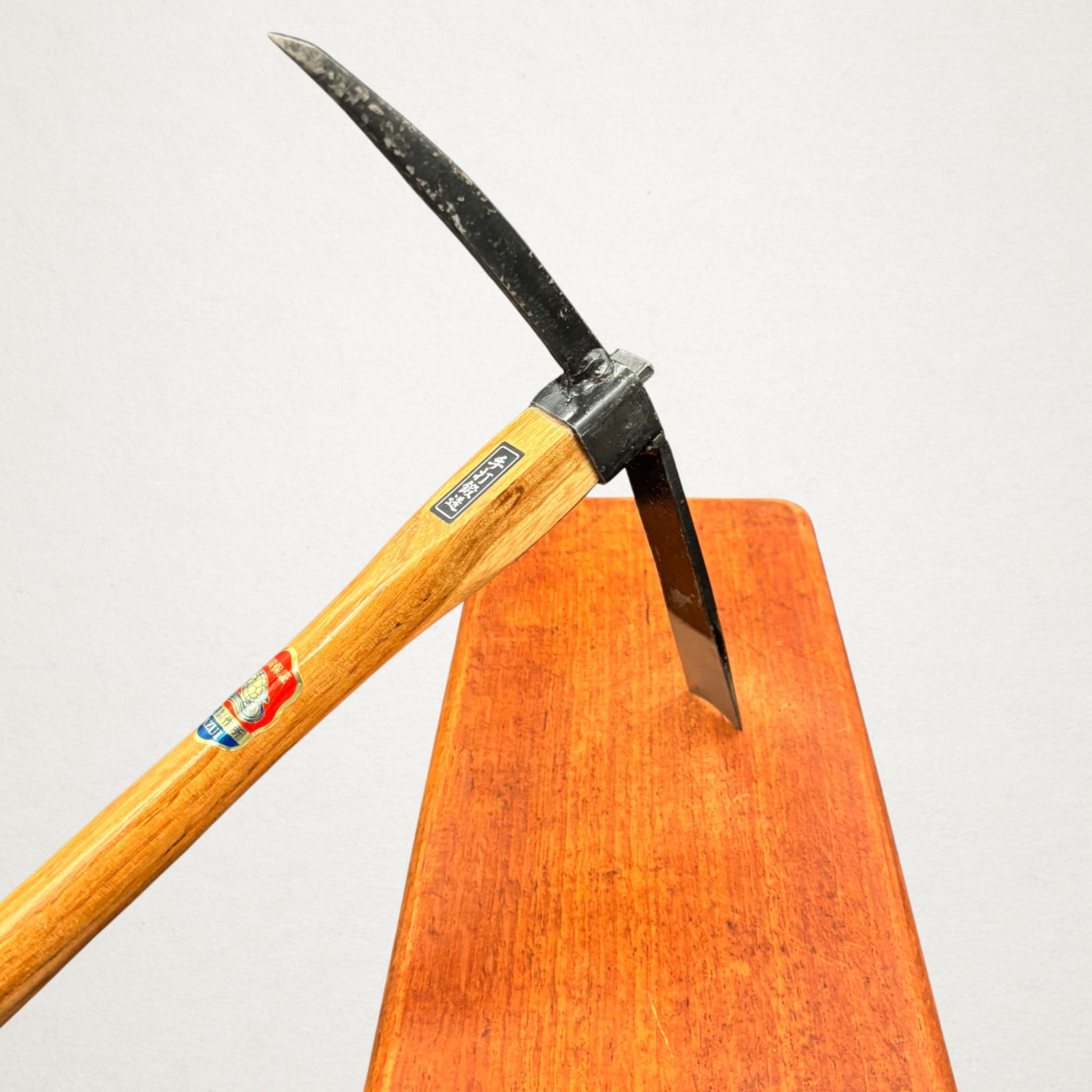 Angled view of Azui No.106 Japanese garden mattock head with curved pick and flat blade