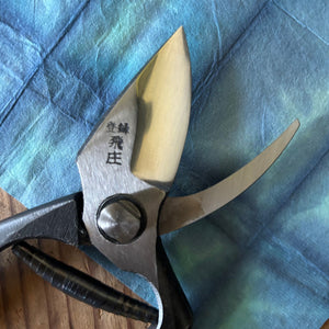 Close-up of Tobisho pruning shears blade and joint, showing steel finish and engraved markings