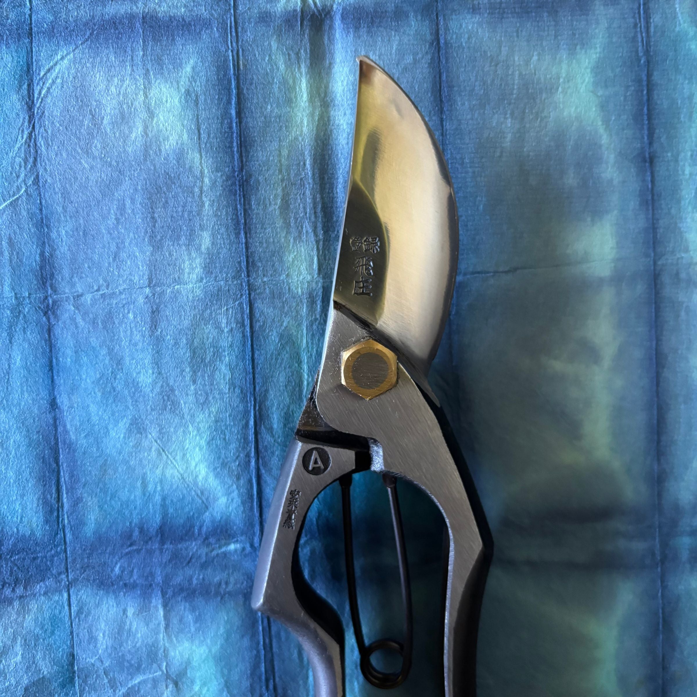 Detail of Tobisho Yasugi blue steel Type-A pruning shear blade with engraved kanji. 