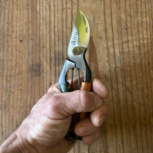 Ikiru secateurs in hand – lifestyle photo showing scale and grip of the green and tan leather-handled secateurs.