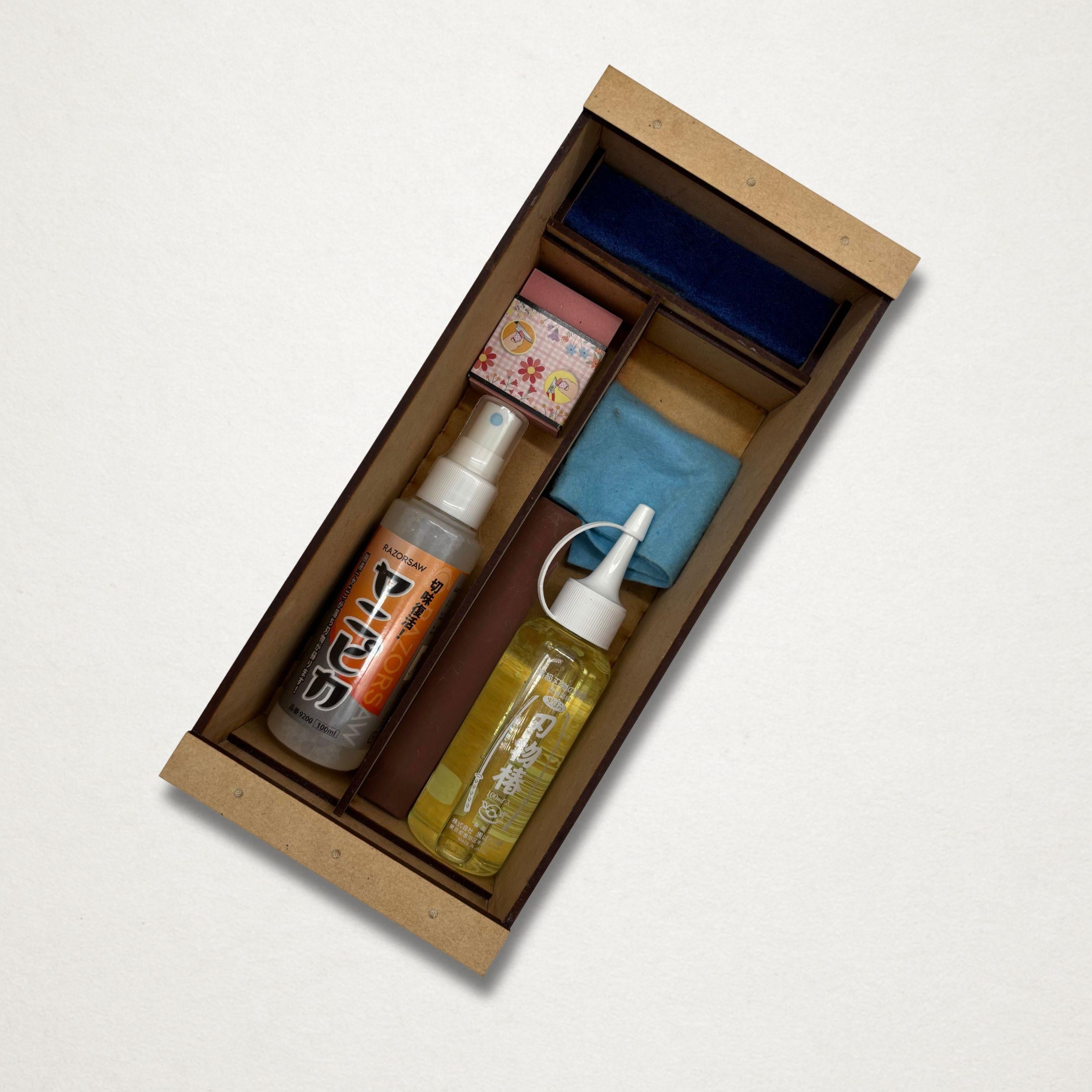 Japanese garden tool maintenance kit in a handmade wooden toolbox with camellia oil, blade cleaner, cloth and sharpening stone.