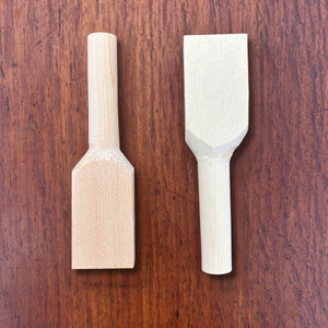 Pair of Japanese hinoki teaspoon blanks photographed from above on a timber surface