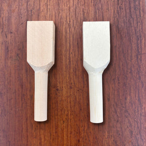 Pair of rough-shaped hinoki teaspoon carving blanks viewed from above on a timber surface