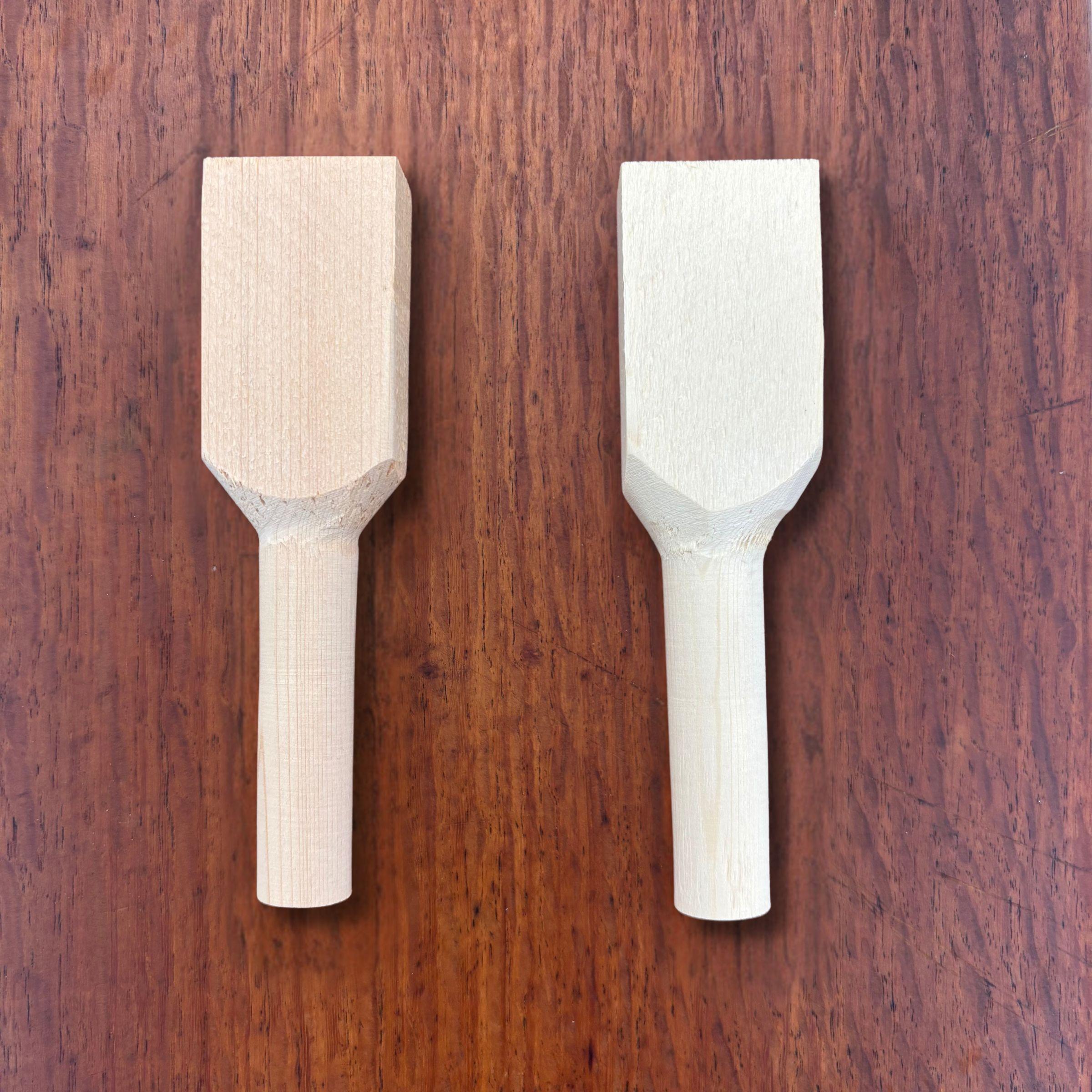 Pair of rough-shaped hinoki teaspoon carving blanks viewed from above on a timber surface
