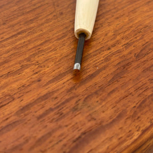 Close-up of a fine detail carving tool from the Michi Hamono Little Jizo carving kit on a wooden board