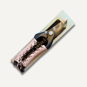 Secateurs with leather grip laying flat on packaging box