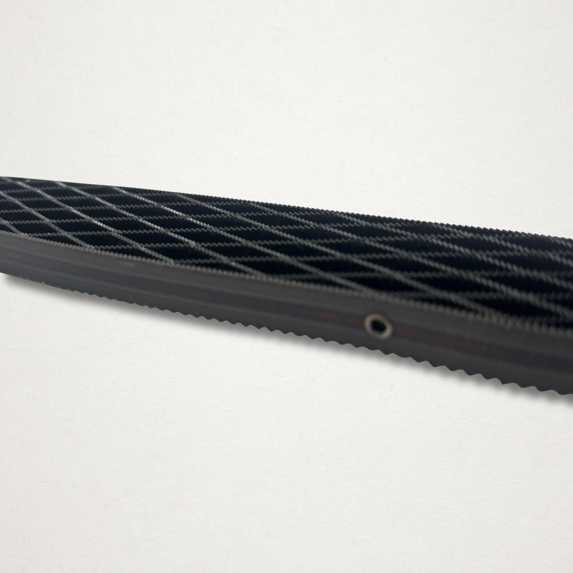 Close-up side view of the Shinto saw rasp blade showing the open lattice teeth and steel side plate