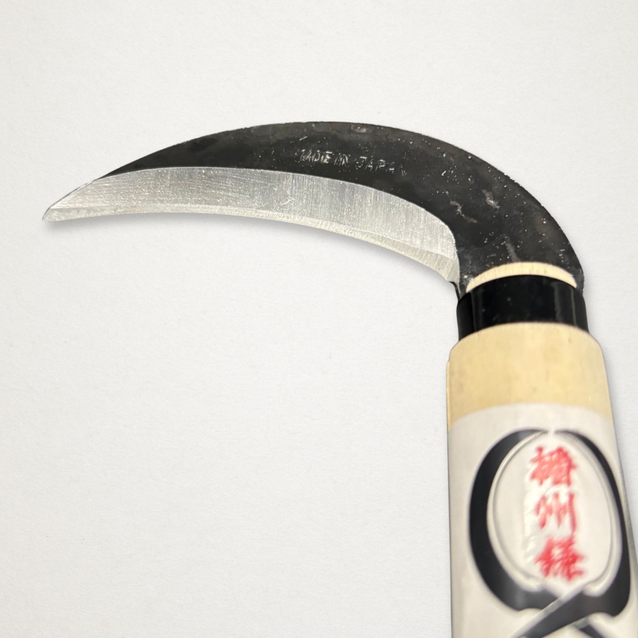 Close-up of Takemoto Kikumatsu mulberry sickle 90mm carbon steel blade with Made in Japan marking