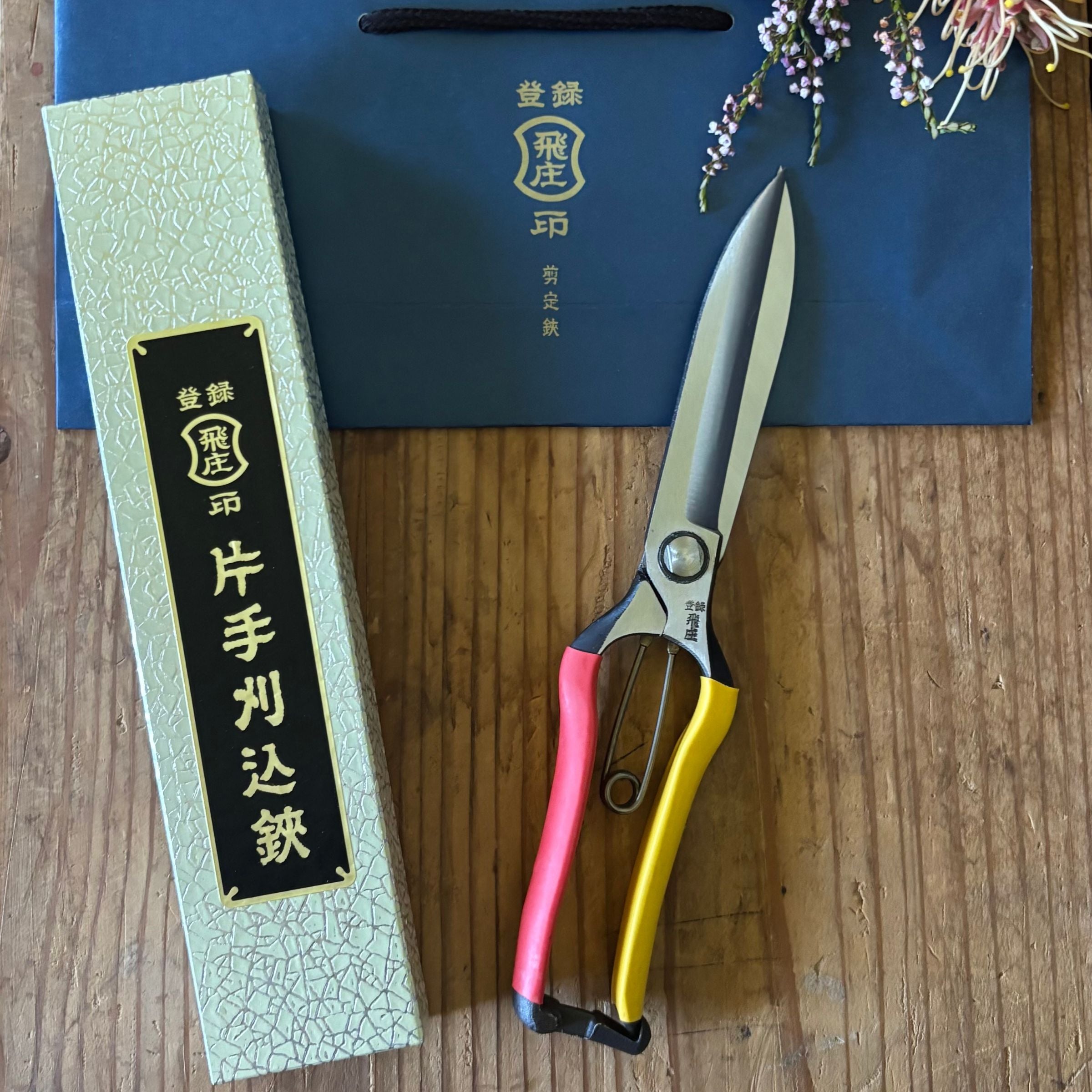 Tobisho Topiary Clippers 270mm – Japanese hedge shears with box and gift bag, styled lifestyle presentation with flowers on wooden surface