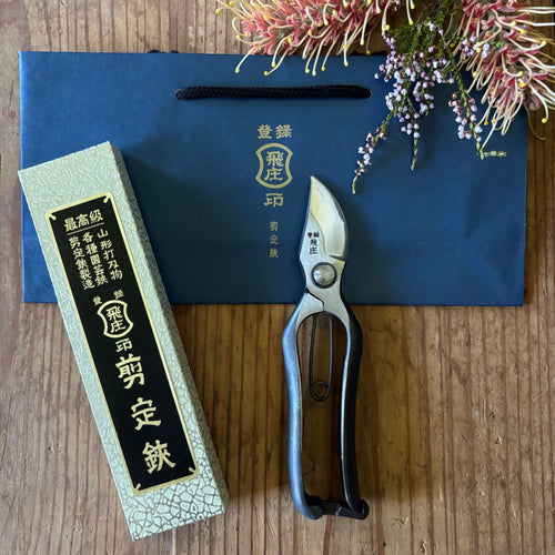 Tobisho Type-B Pruning Shears 200mm with box and gift bag, made in Japan, displayed on wooden table with native flowers