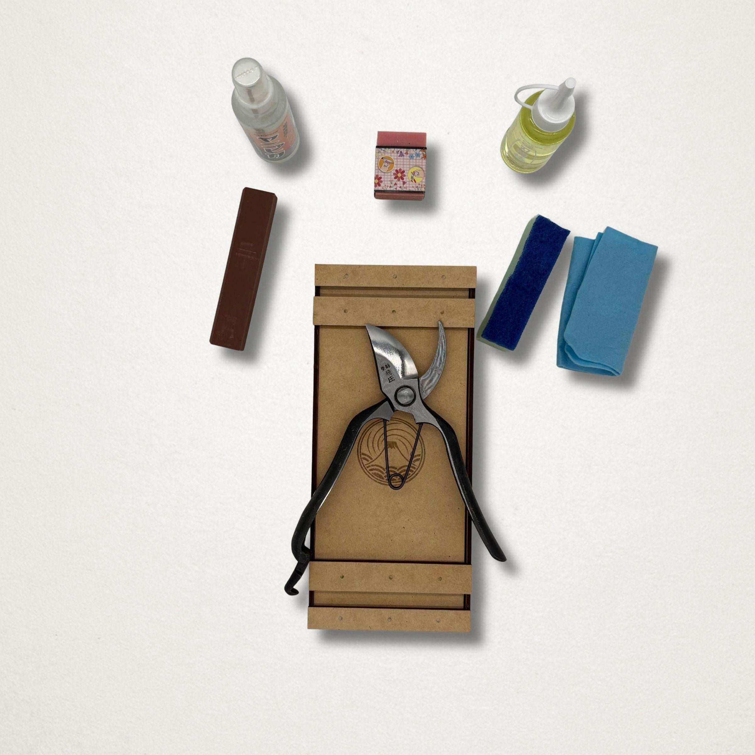 Tobisho Type B pruning shears and Japanese garden tool maintenance kit contents laid out beside a handmade wooden toolbox.