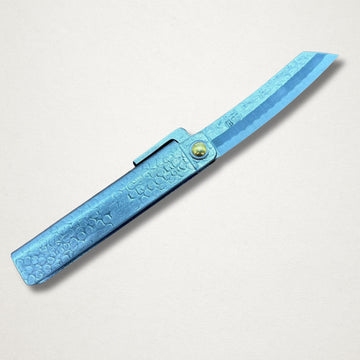 Japanese higo knife with hammered blue steel handle and open blade on white background