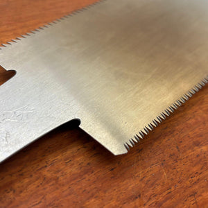 Angled close-up of the Japanese saw blade showing fine teeth and steel finish
