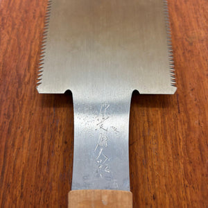 Close-up of the Japanese saw tang with engraved maker’s mark above the handle