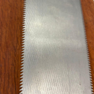 Close-up of fine rip teeth and textured blade finish on vintage Japanese Rhona saw