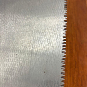 Close-up of crosscut toothline and etched hammer-textured blade surface on vintage Japanese ryoba saw