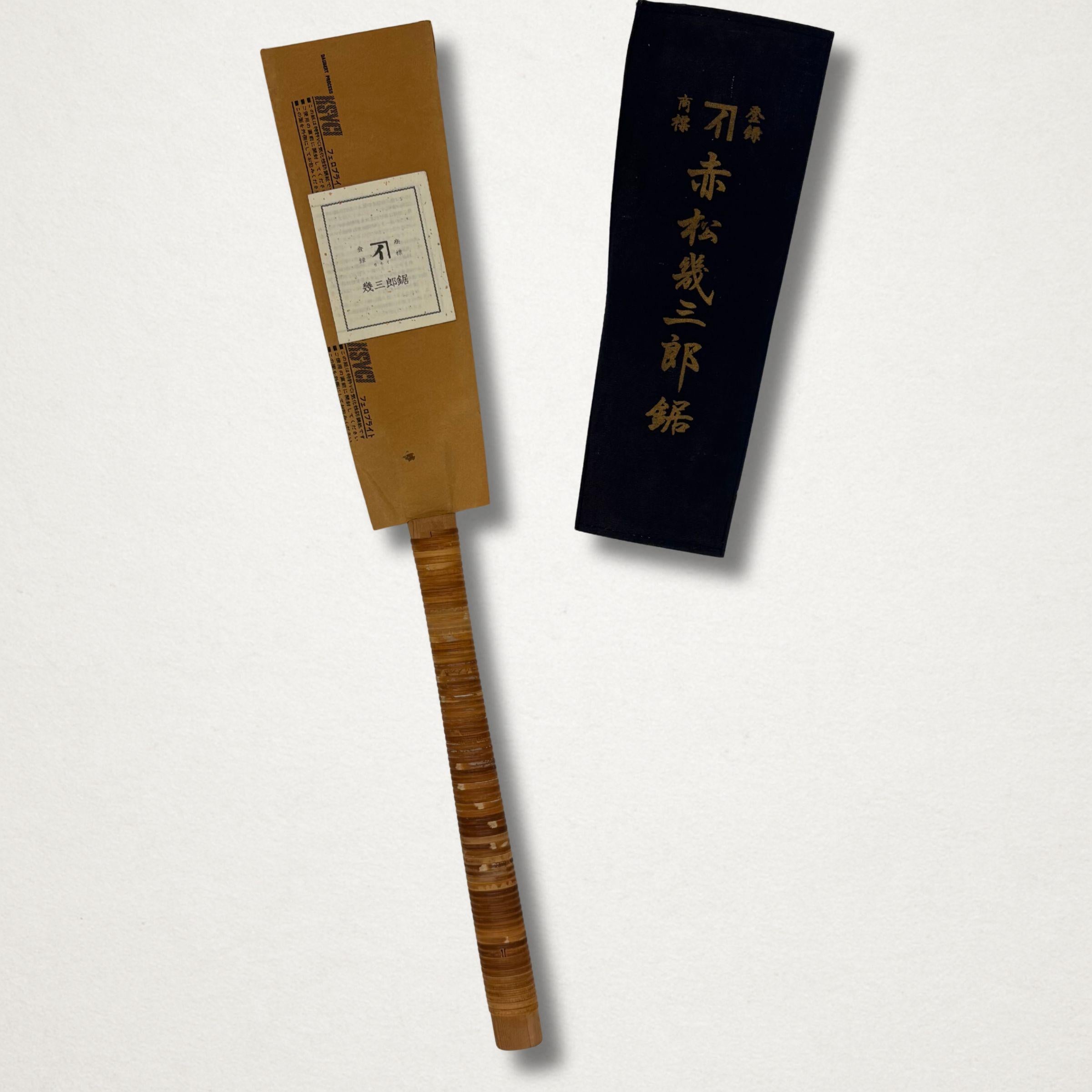 Vintage Japanese 240mm ryoba saw shown with original paper blade sleeve and dark blue cloth cover
