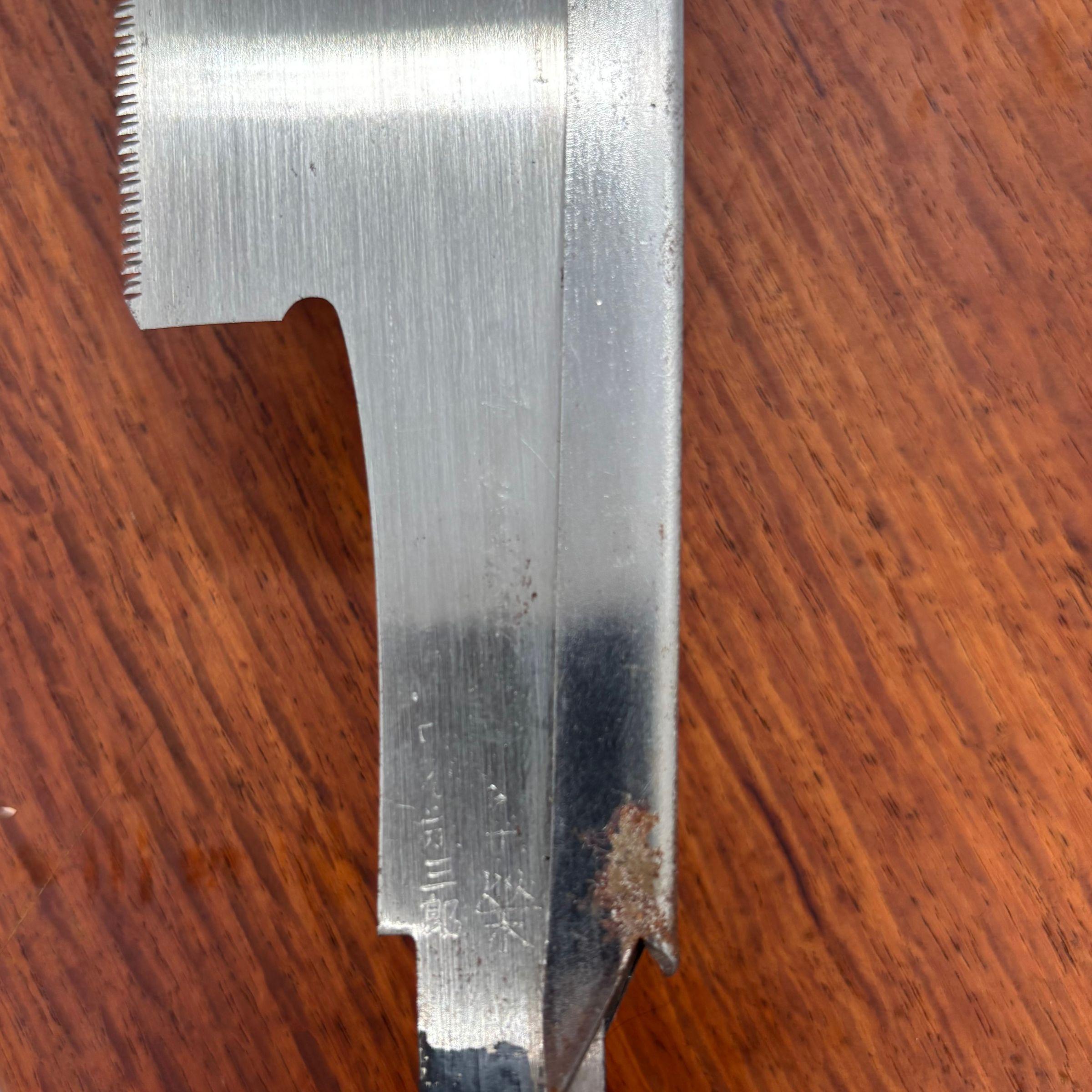Close-up of the forge-welded tang on a vintage Japanese dozuki saw with light oxidation near the handle