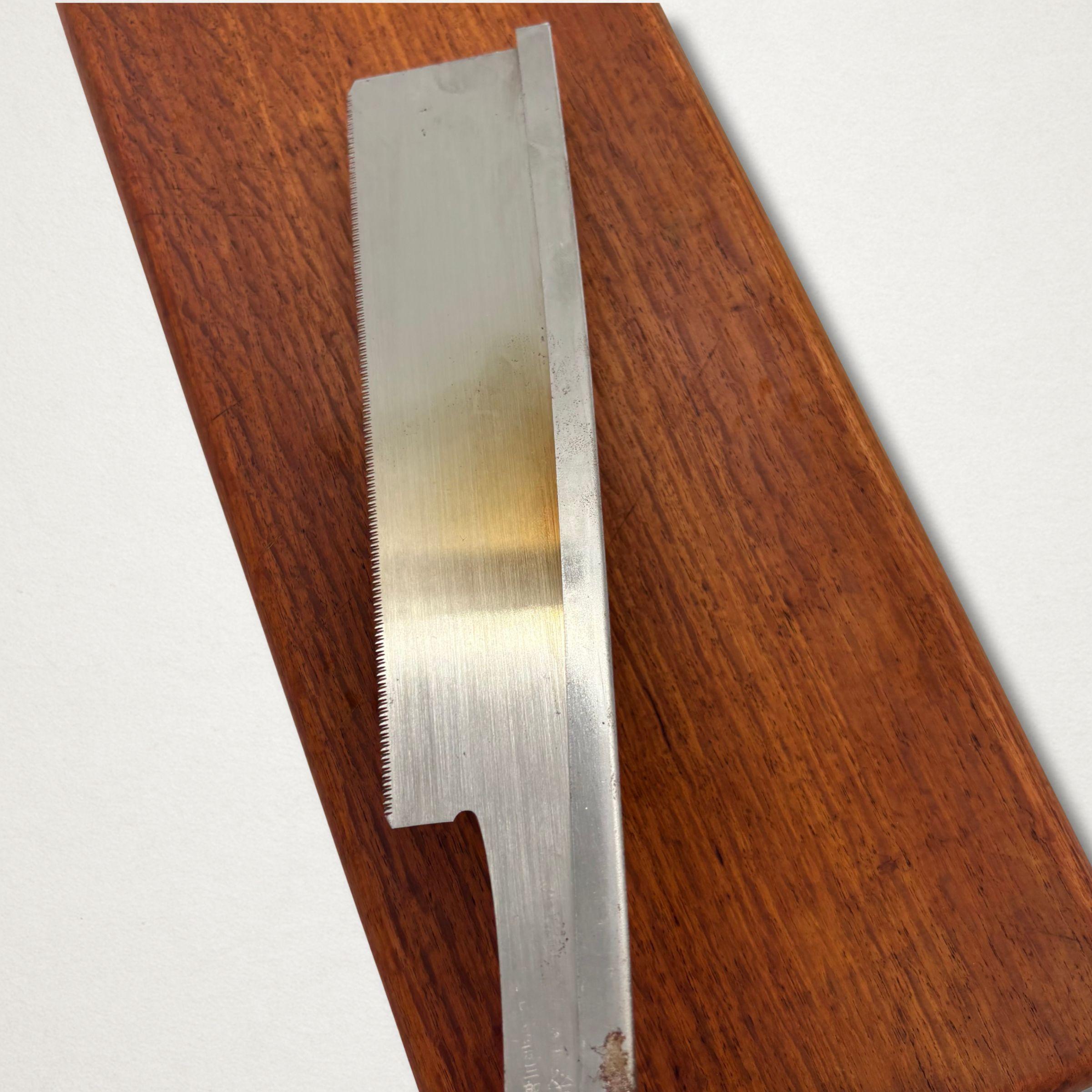 Close-up angled view of a vintage Japanese dozuki saw blade showing temper colour and fine toothline