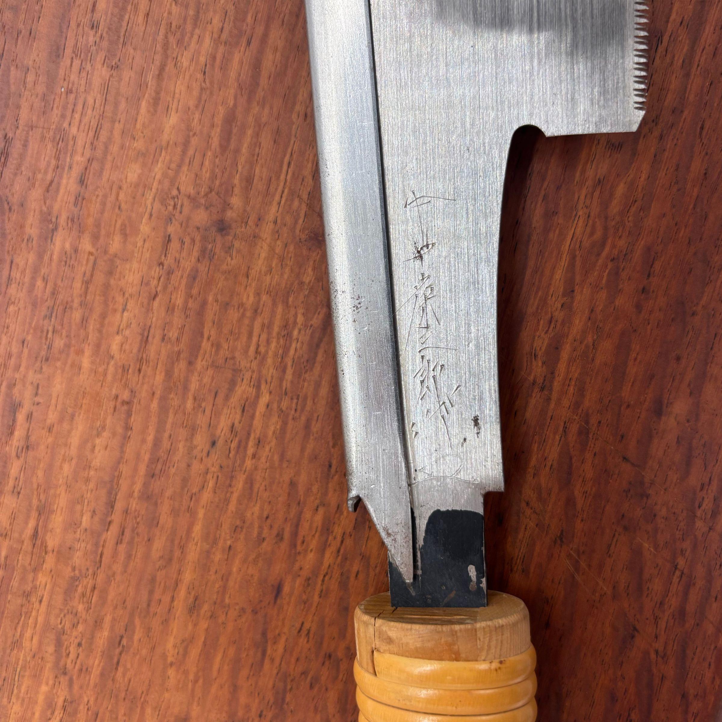 Close-up of the forge-welded tang on a vintage Japanese dozuki saw with cane-wrapped handle