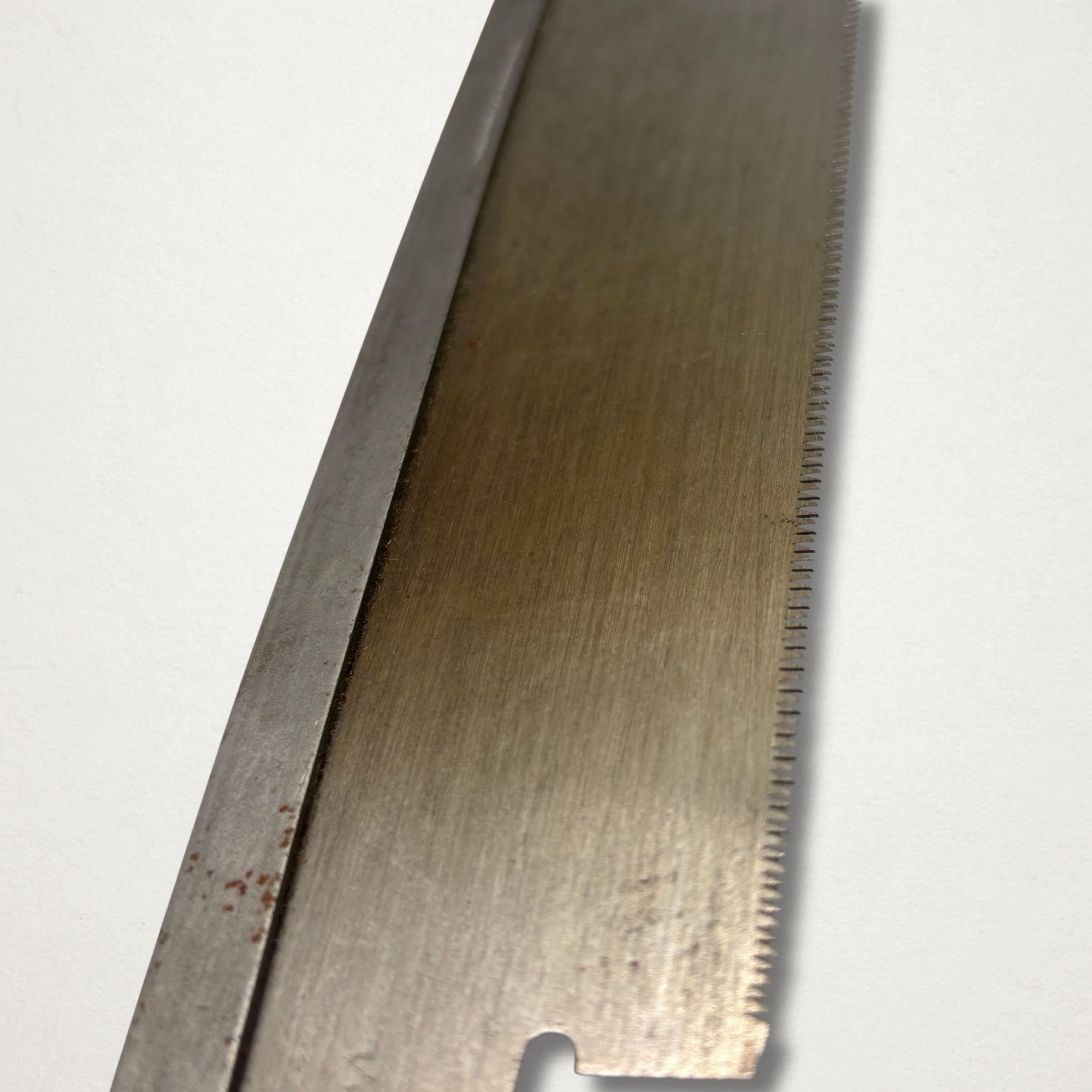 Close-up of vintage Japanese 240mm dozuki saw blade showing fine joinery teeth and hand-finished steel surface.