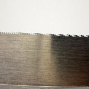 Close-up of the toothed edge on a vintage Japanese 240mm dozuki saw with visible temper colour and fine tooth pattern.