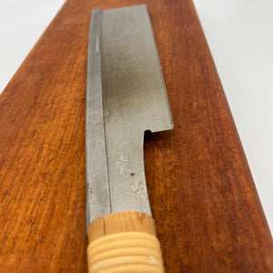Angled side view of a vintage Japanese 240mm dozuki saw with cane-wrapped wooden handle and backed blade.