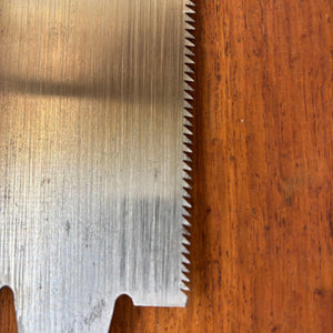 Close-up of the toothline on a vintage Japanese ryoba saw showing sharp triangular teeth and cleaned blade surface