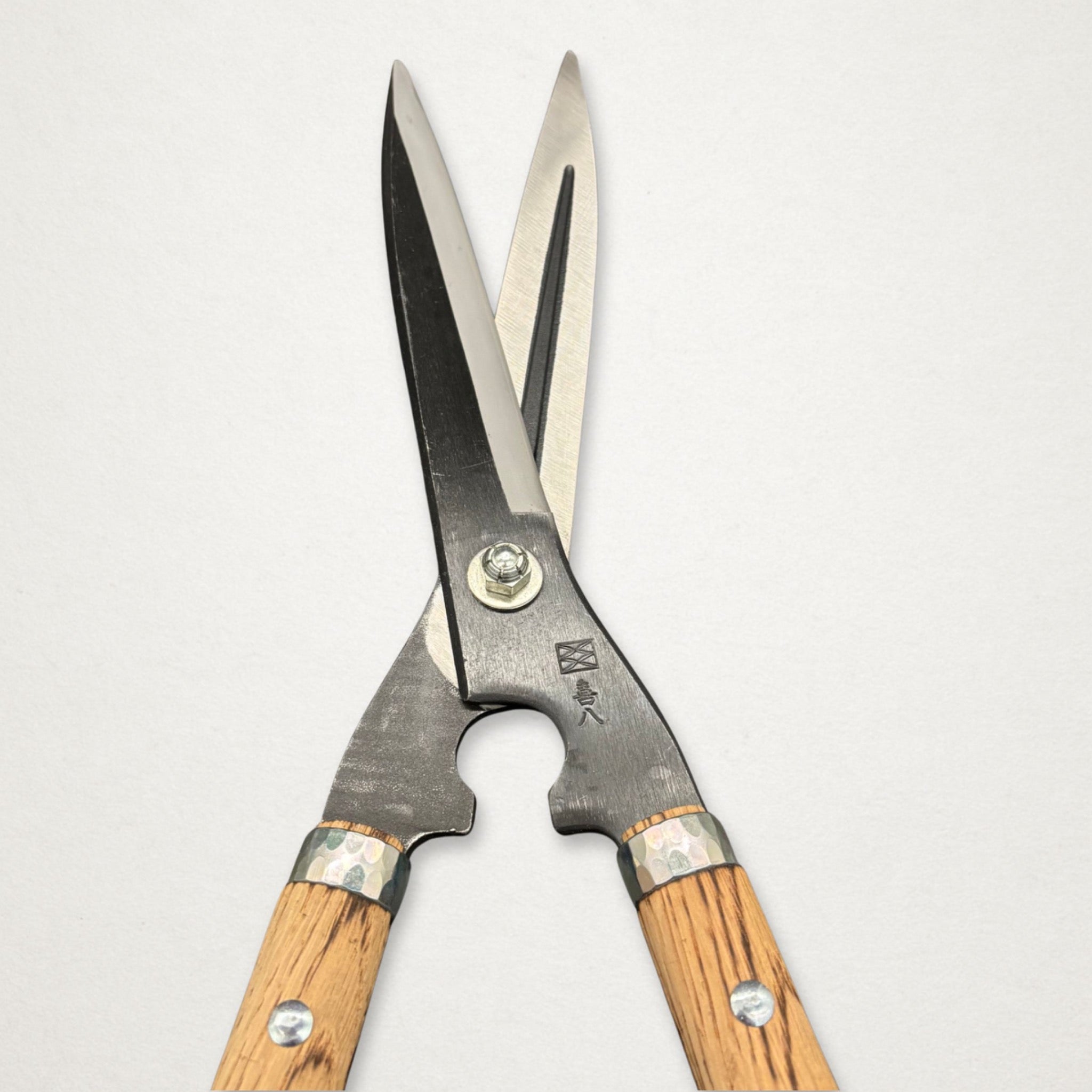 Close-up of Yoshioka Masamune Japanese hedge shears pivot, forged body and burnt oak handle detail