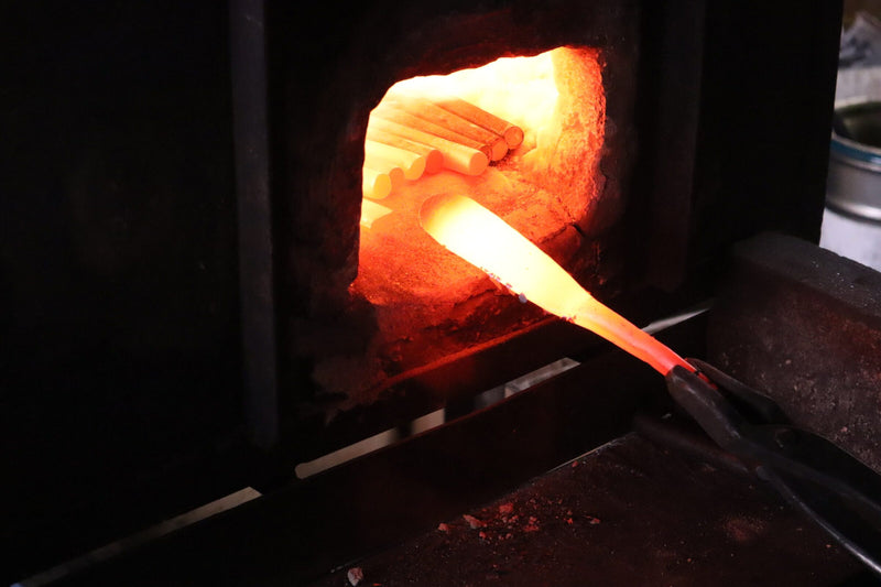 Heating a secateur blank inside the furnace.