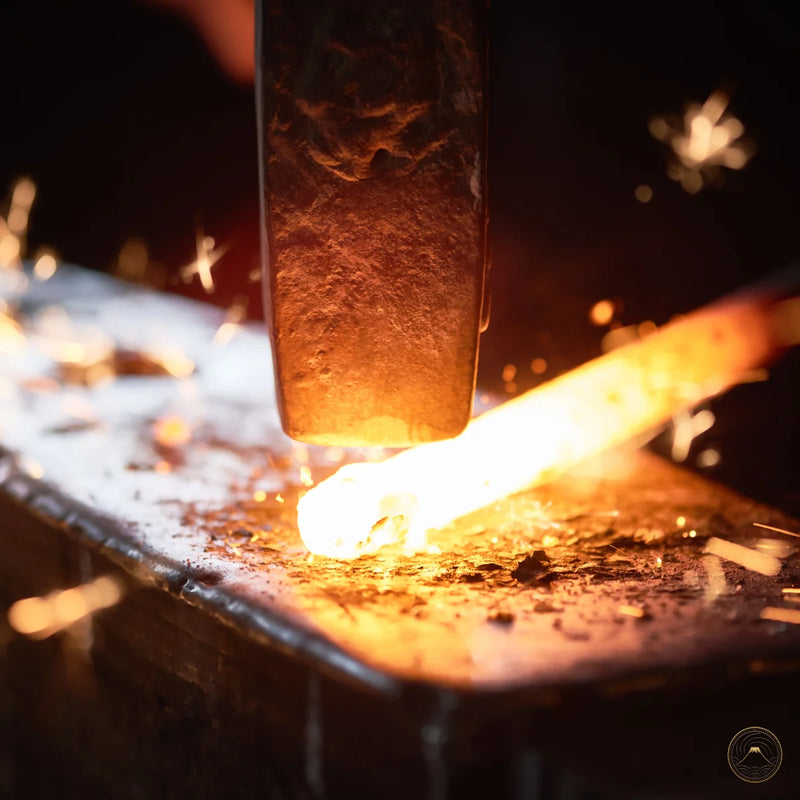 Close-up of a metal forging process with sparks and glowing metal.